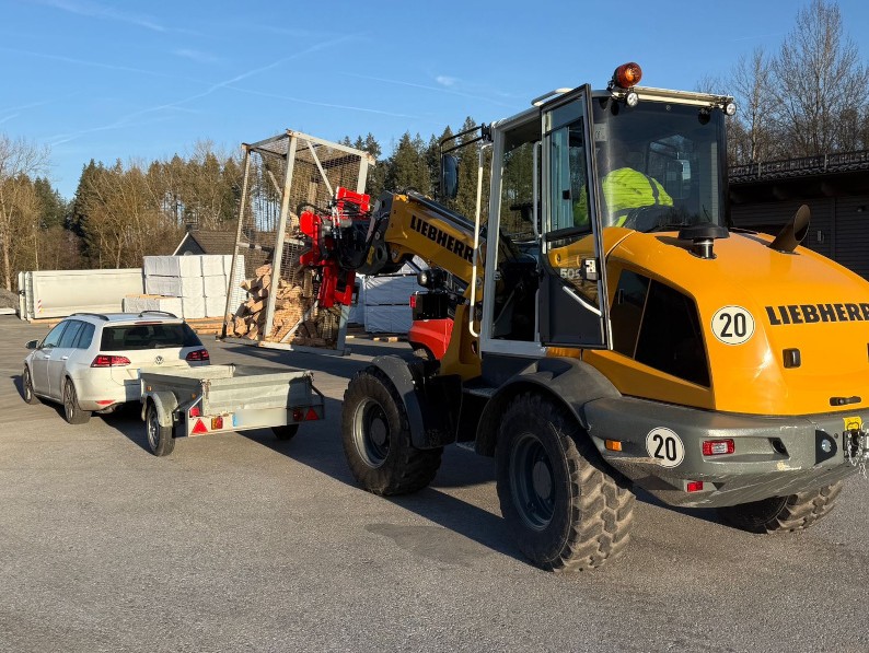 Das Buchen-Brennholz wird mit dem Frontlader aus den Gitterboxen aufgeladen.